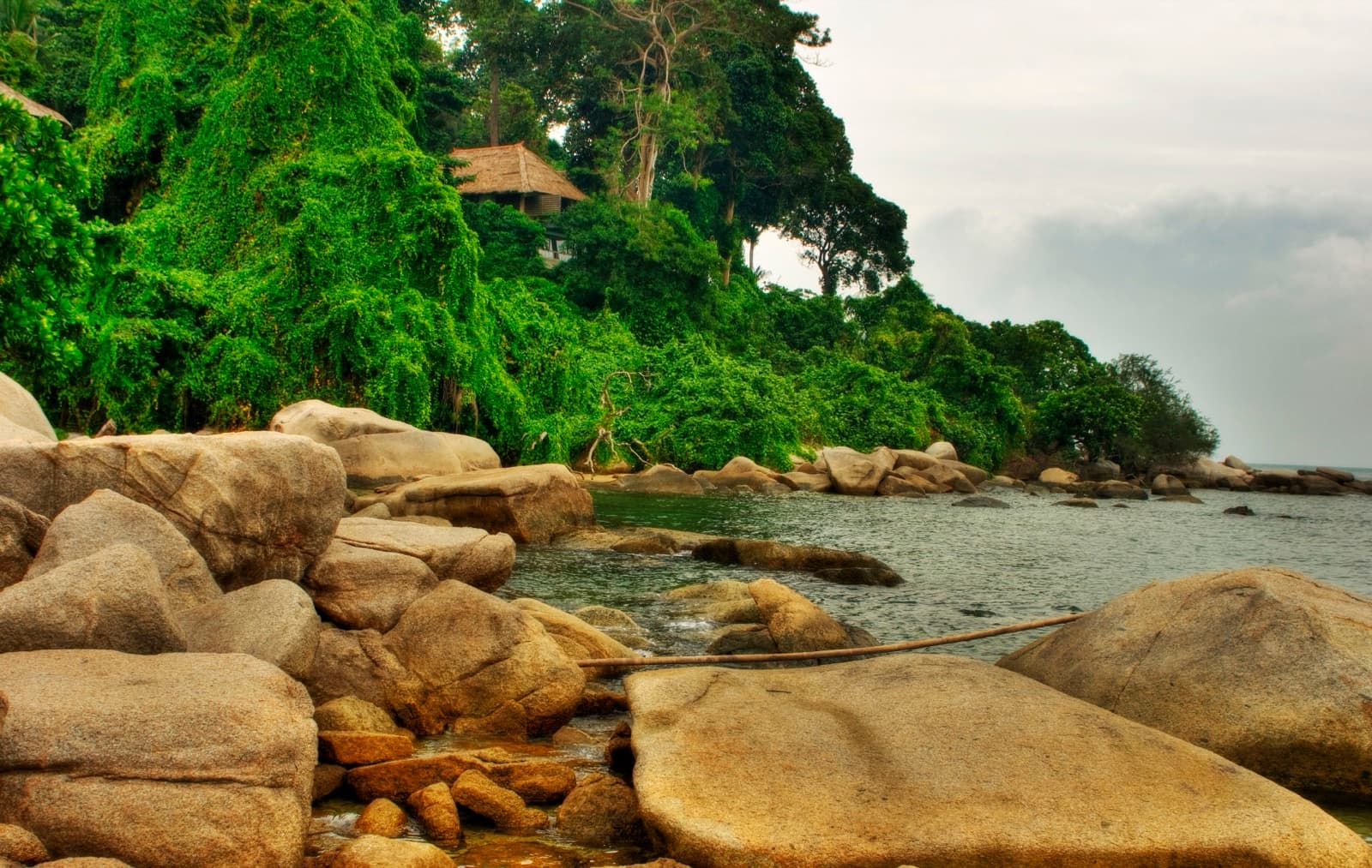 Granite shoreline and dense tropical greenery at Banyan Tree Bintan in Lagoi