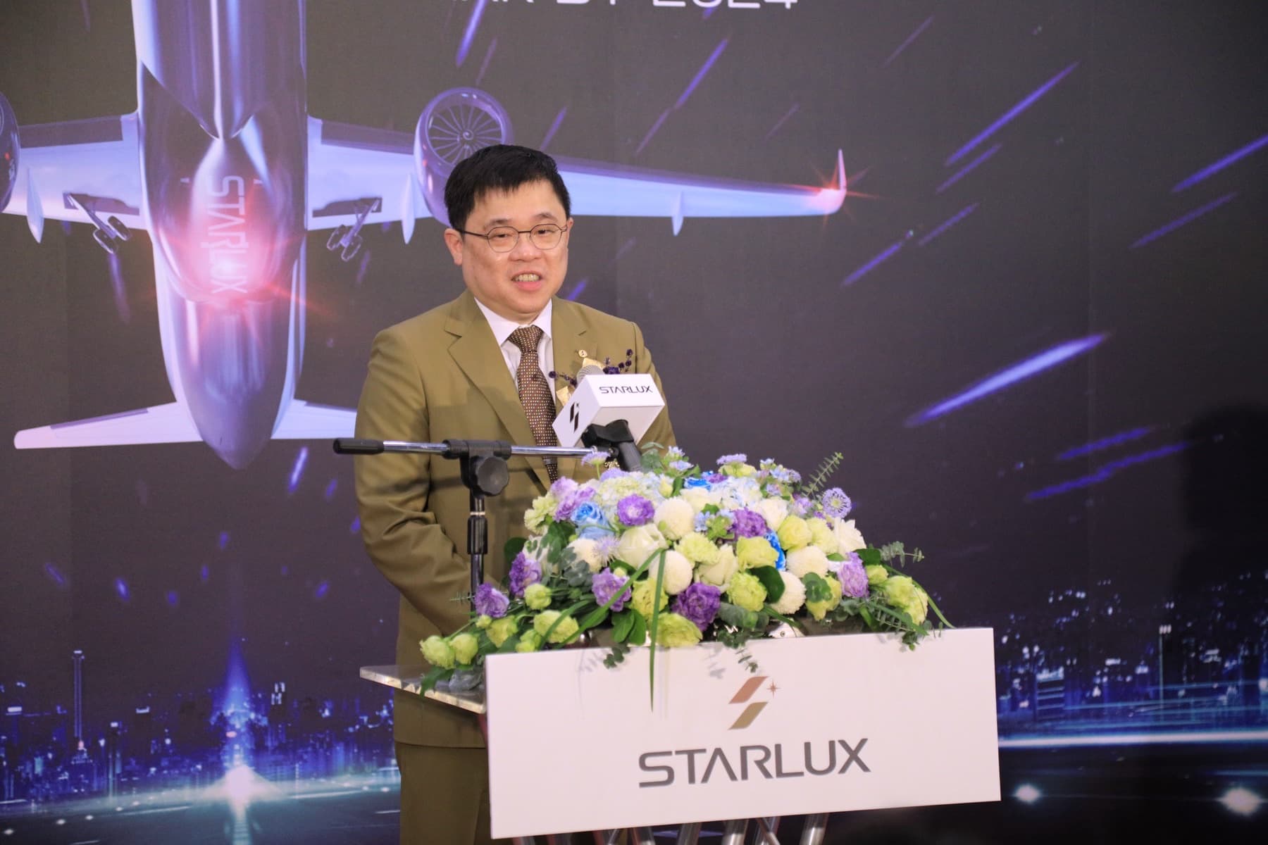 STARLUX Airlines founder and chairman Chang Kuo-wei speaking at a lectern marked with the carrier’s star