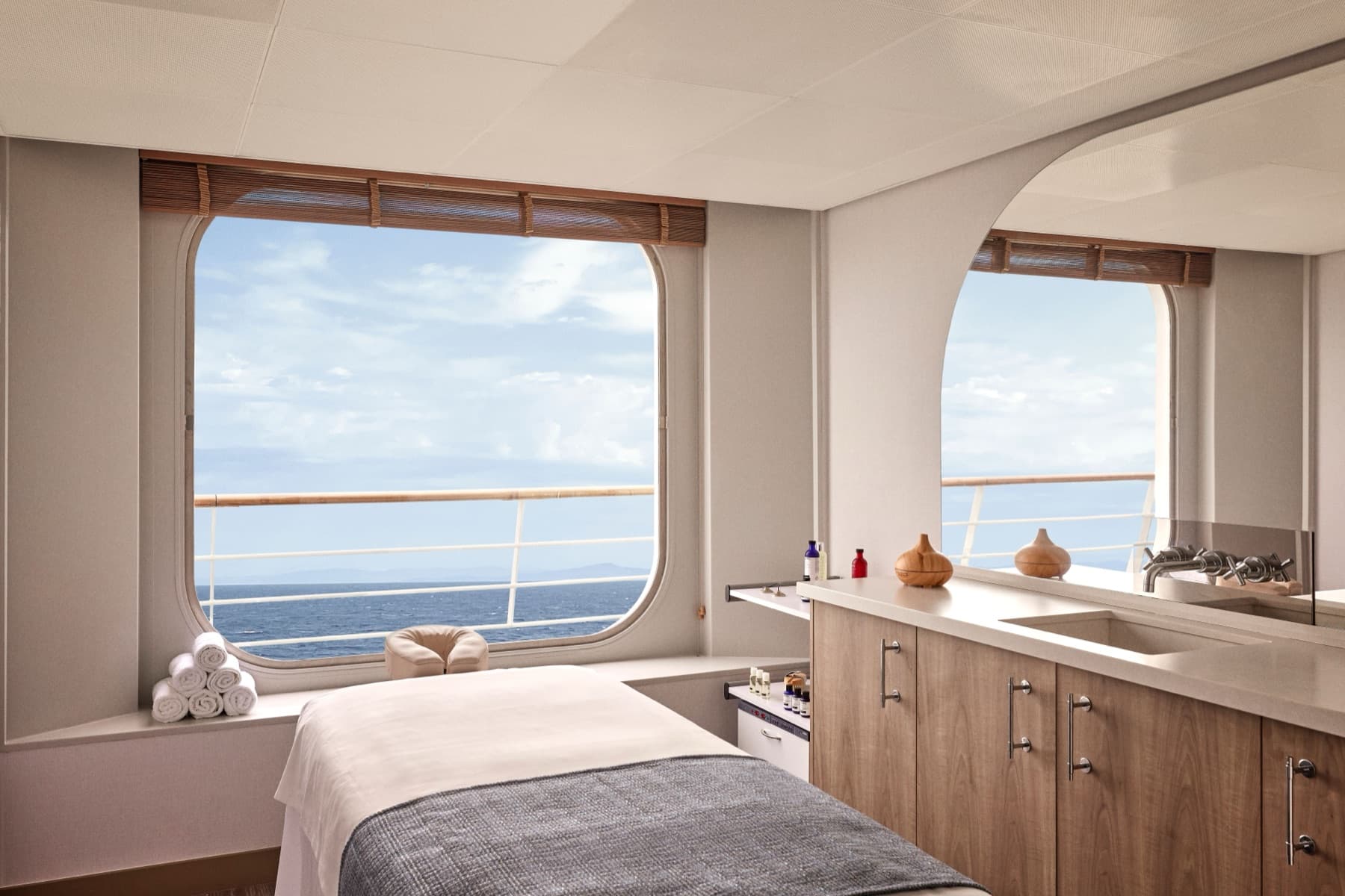 Aurōra Spa treatment room aboard a Crystal ship with a prepared massage table facing a large ocean-view window