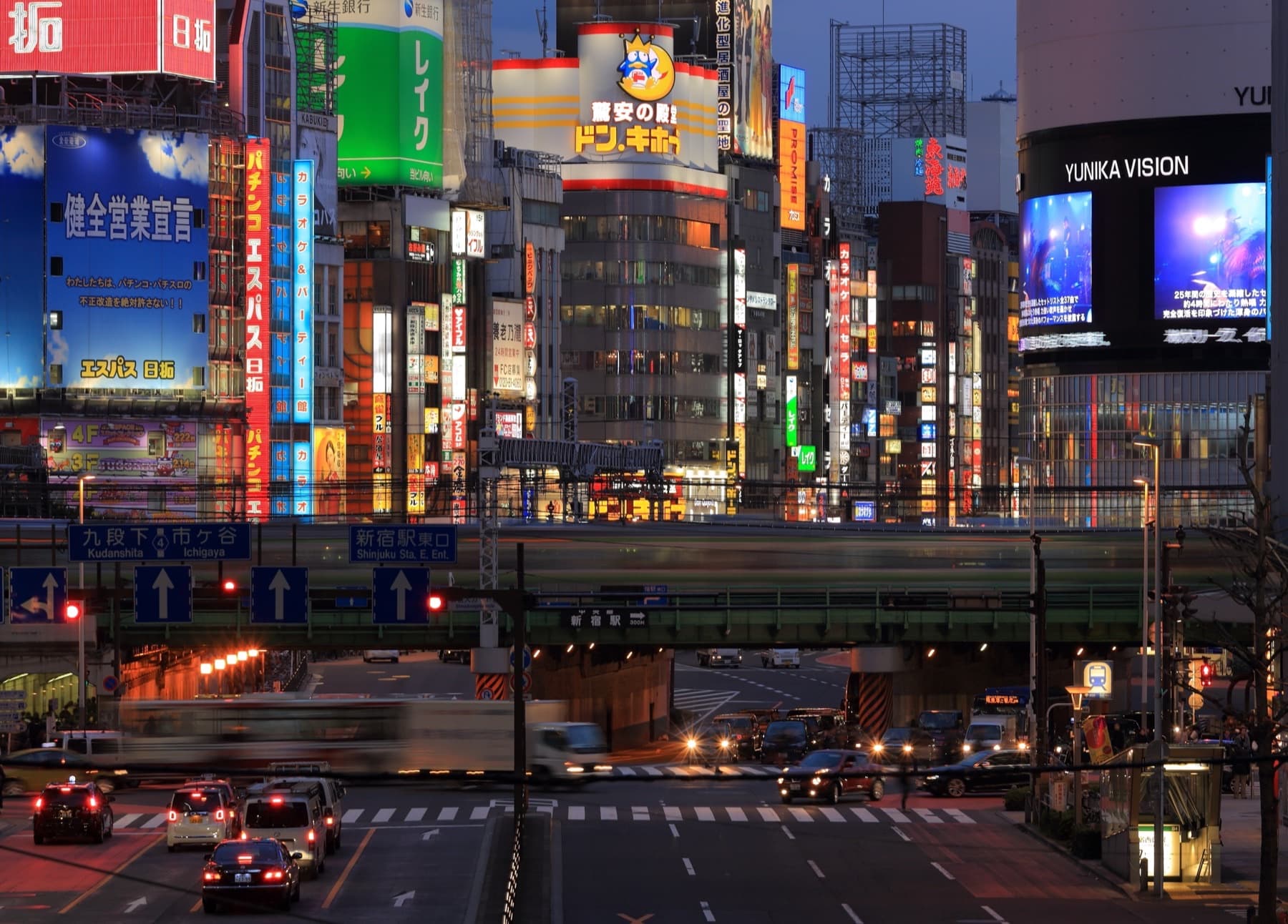 Night traffic and lit towers along Ōme-kaidō in Shinjuku, Tokyo