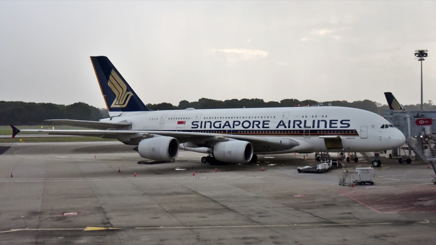 Singapore Airlines Airbus A380 9V-SKN on the apron in Singapore, white fuselage and gold Kris tail — Singapore Airlines Is Adding Nearly 25% More A380 Flights This Winter