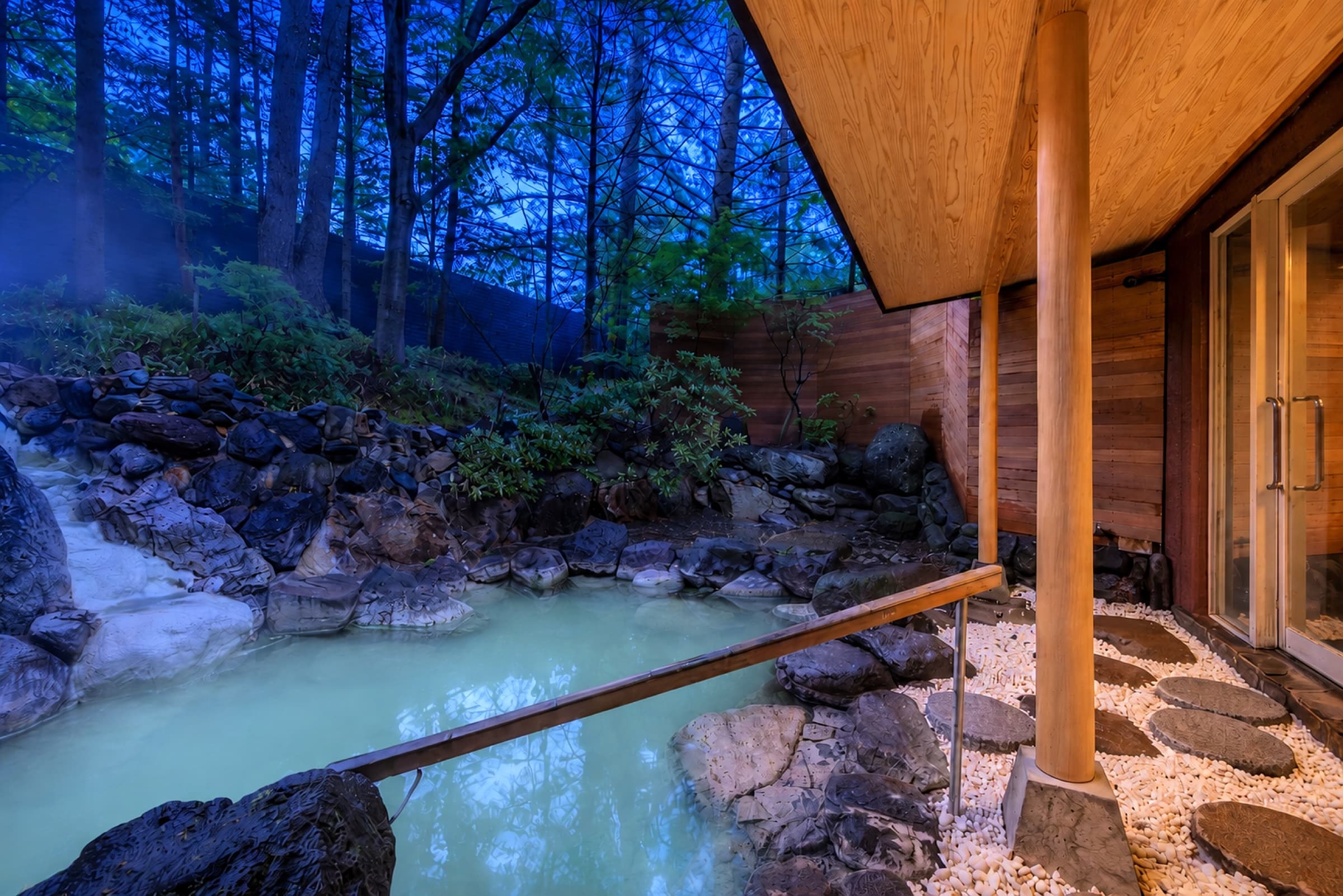 Open-air sulfur rock bath beside the wooden lodge at UNWIND HOTEL & BAR OKUNIKKO in Nikko National Park — A 1959 Onsen Lodge Just Got a Boutique Second Life in Nikko National Park
