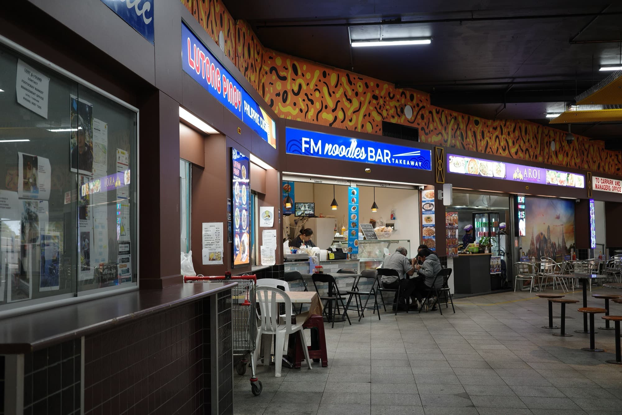 Food shops and seating inside Footscray Market in September 2025