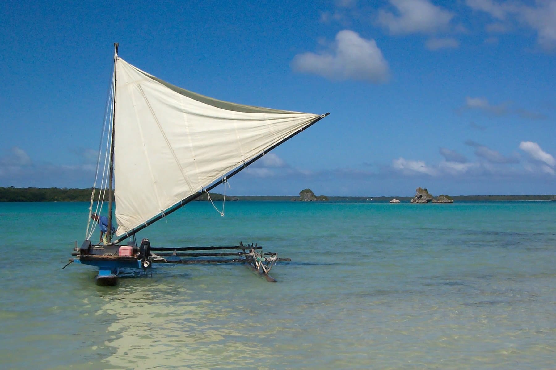 Traditional sailing pirogue in clear water off Île des Pins, New Caledonia