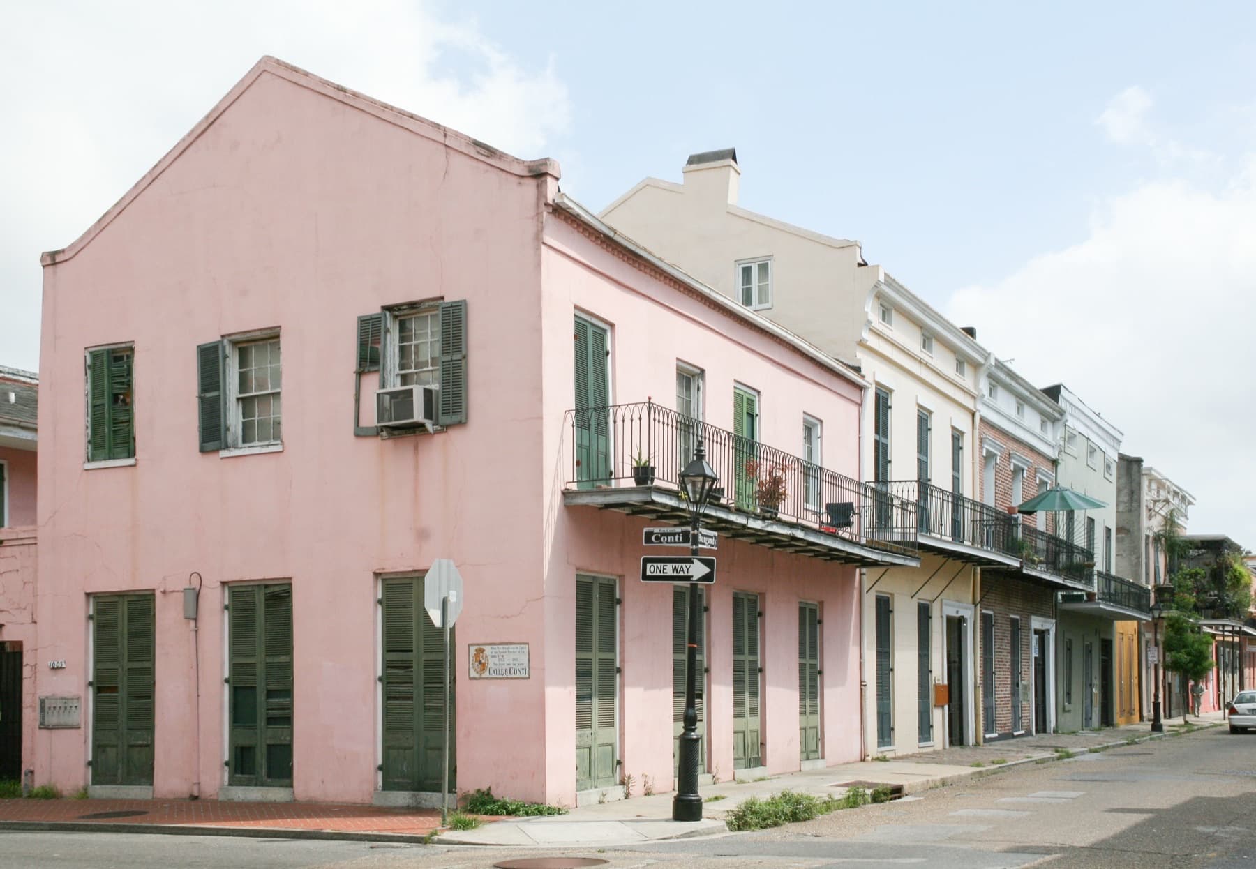 Burgundy Street in the French Quarter of New Orleans with iron balconies and parked cars