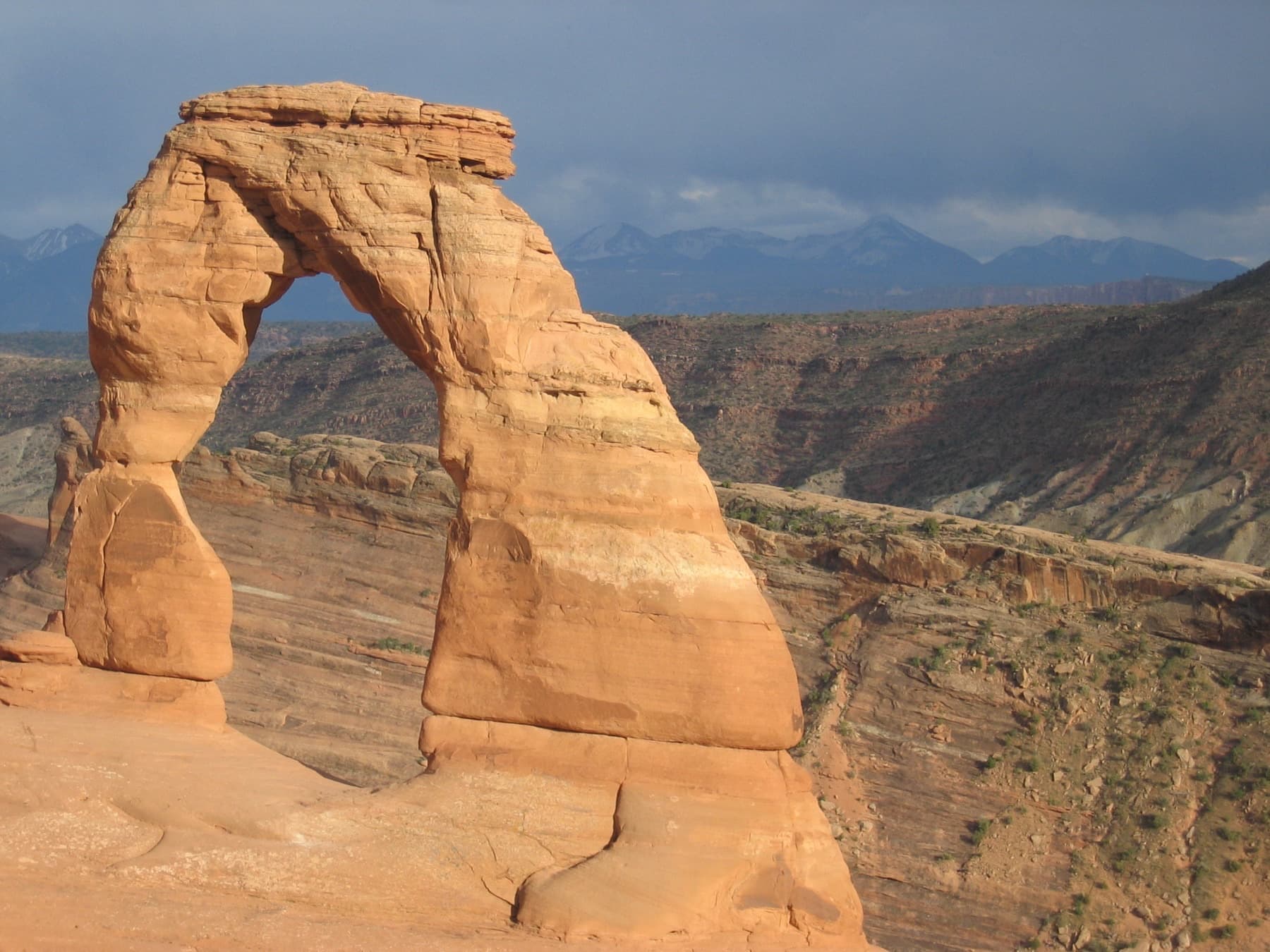 Delicate Arch glowing orange against a blue sky in Arches National Park, Utah